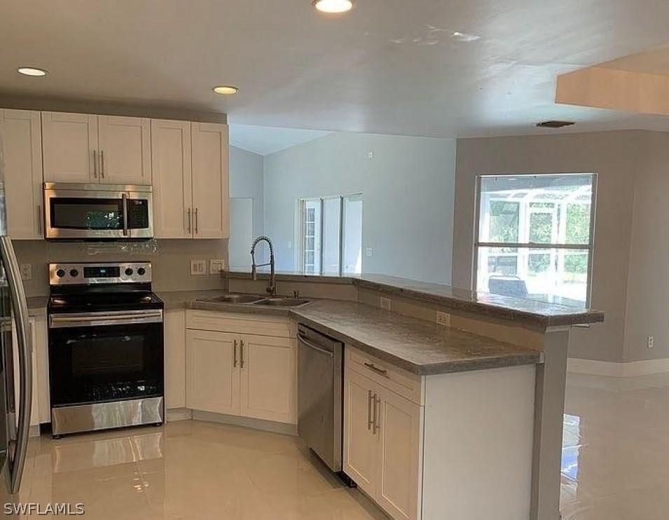 3353 Captains Cove Naples, FL 34112 - Photo 3 of 13 a kitchen with a sink stove and microwave
