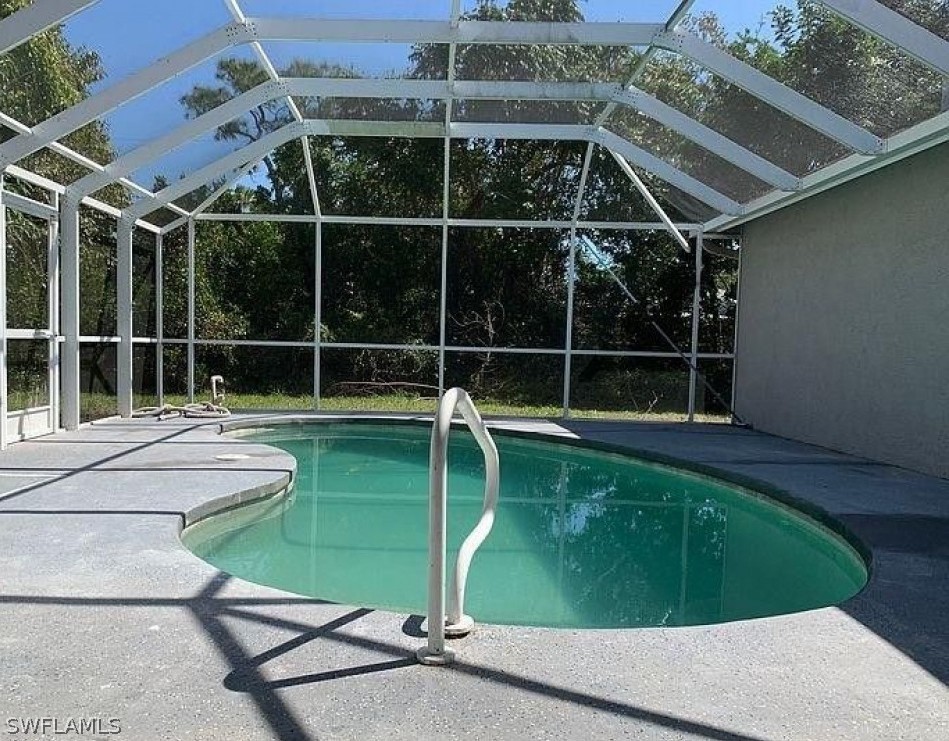 3353 Captains Cove Naples, FL 34112 - Photo 9 of 13 a view of a swimming pool with a yard and wooden floor