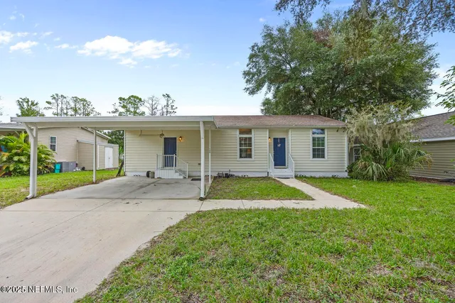 a view of a house with a backyard