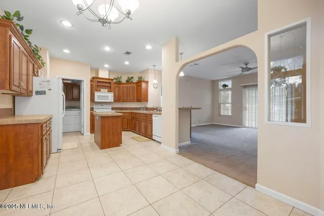 a kitchen with stainless steel appliances kitchen island granite countertop a refrigerator and a stove top oven