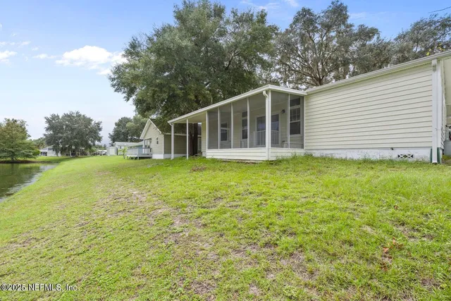 a view of a house with a yard and tree