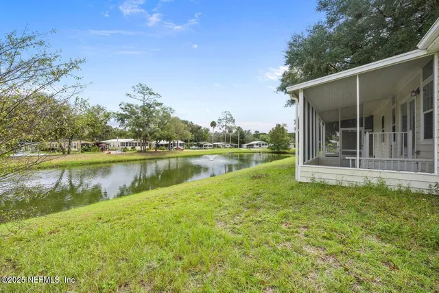 a view of a house with backyard and a tree