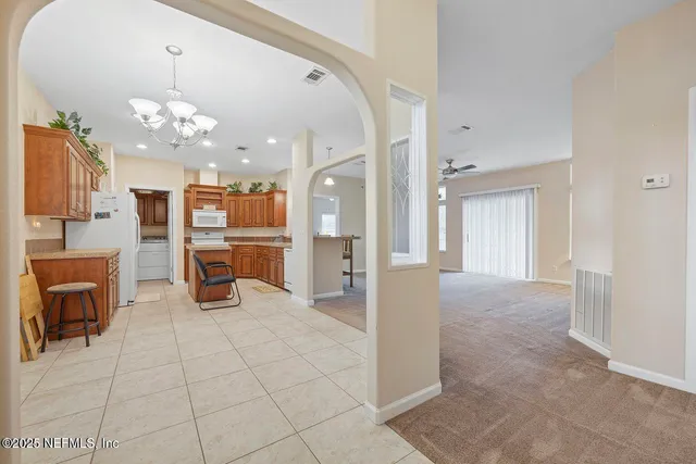 a view of a livingroom with a furniture a chandelier and fireplace