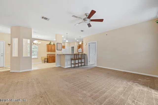 a view of a livingroom with a ceiling fan and window
