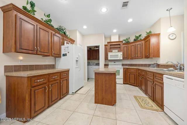 a kitchen with stainless steel appliances granite countertop a stove top oven a sink dishwasher and a cabinets with wooden floor