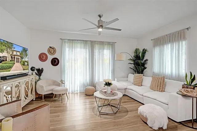 a kitchen with a refrigerator a microwave a stove and white cabinets with wooden floor