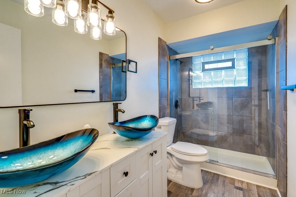 6961 Maplewood Road Parma Heights, OH 44130 - Photo 10 of 22 Bathroom with a shower with door, vanity, hardwood / wood-style floors, and toilet