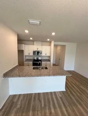 a large kitchen with kitchen island a sink stainless steel appliances and a counter space