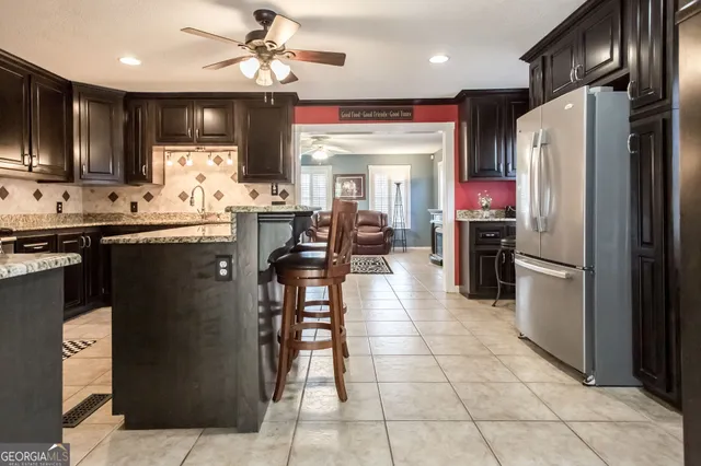 a kitchen with stainless steel appliances granite countertop a refrigerator a sink and a stove