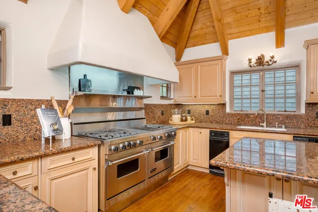 a kitchen with stainless steel appliances granite countertop a stove and a white cabinets
