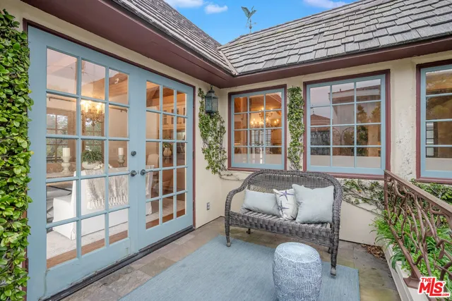 a balcony with furniture and next to a window