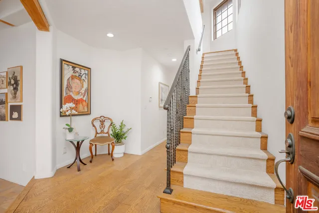 a view of entryway and hall with wooden floor