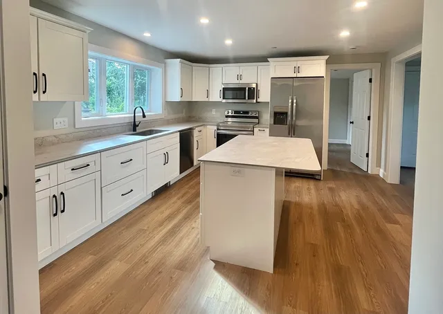 a kitchen with stainless steel appliances a refrigerator sink and cabinets