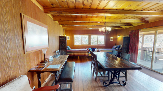 315 Abbey Road Moab, UT 84532 - Photo 12 of 46 Dining space with hanging lights, wood walls, a wood ceiling with exposed beams, and dark wood finished floors