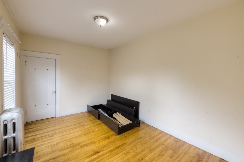39 Woodford Street, Unit 3 Worcester, MA 01604 - Photo 29 of 37 a bedroom with a bed and wooden floor