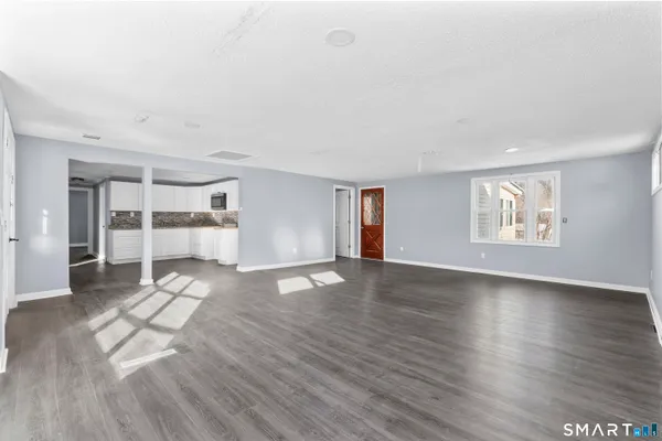 a view of empty room with wooden floor and window