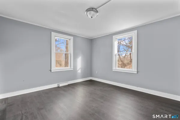 a view of an empty room with wooden floor