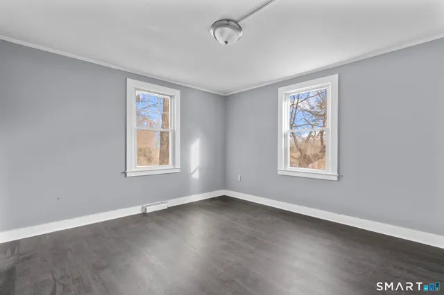 a view of an empty room with wooden floor