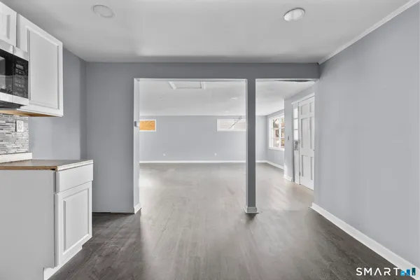 a view of a big room with wooden floor and windows