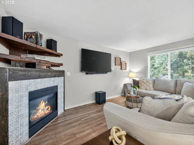 a living room with furniture a flat screen tv and a fireplace