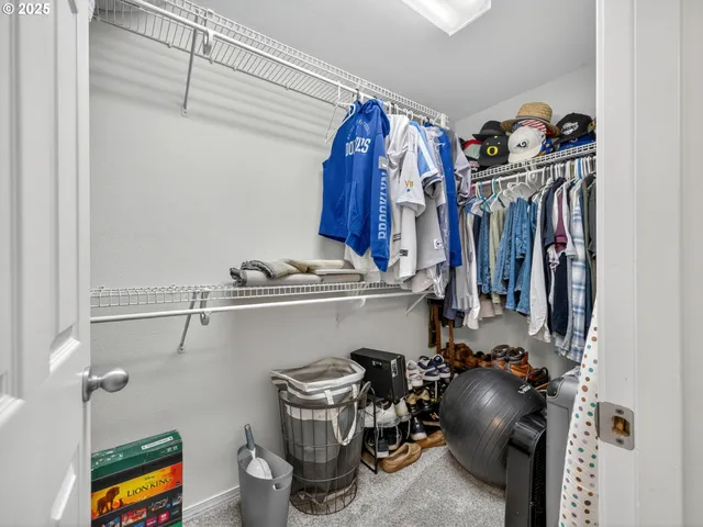 a view of walk in closet with clothes and shoes