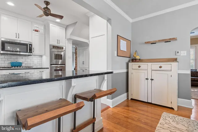 a kitchen with cabinets and wooden floor