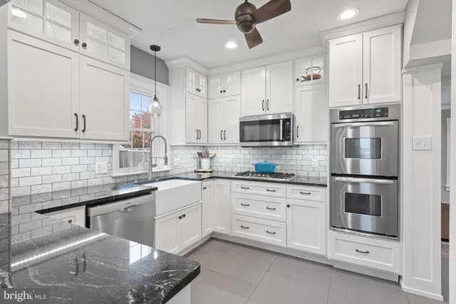 a kitchen with white cabinets stainless steel appliances and sink
