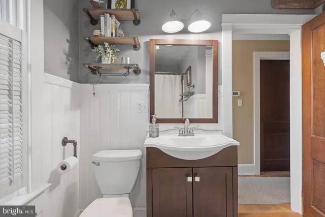 a bathroom with a sink vanity mirror and toilet