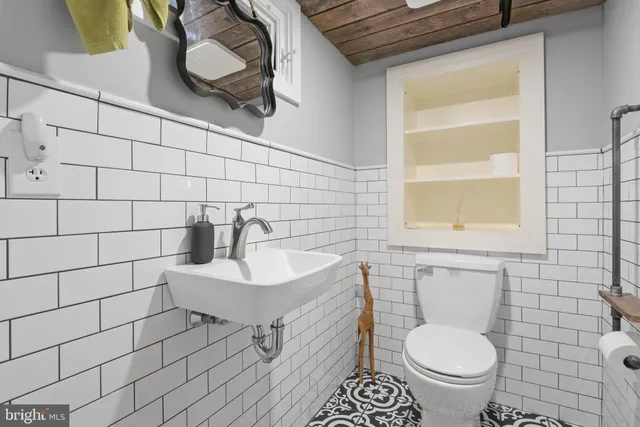 a bathroom with a sink a toilet and a mirror