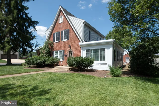 a front view of a house with a yard and trees