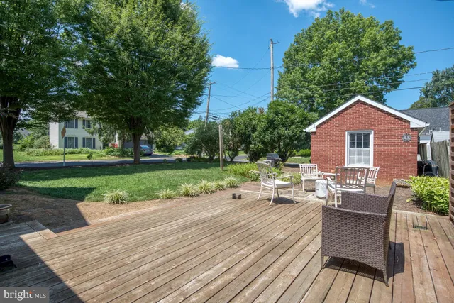 a view of a patio with table and chairs with wooden floor and fence