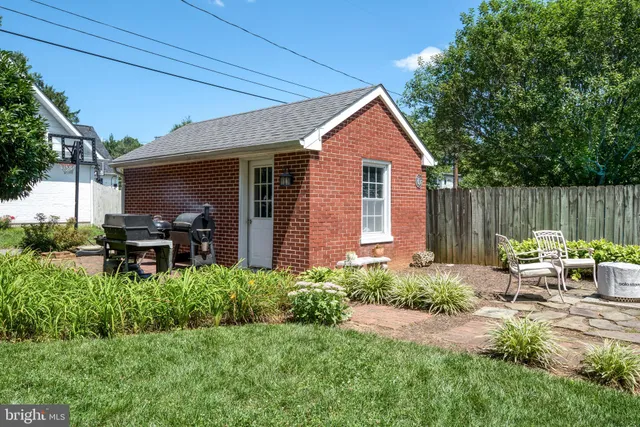 a view of backyard of house with outdoor seating and green space