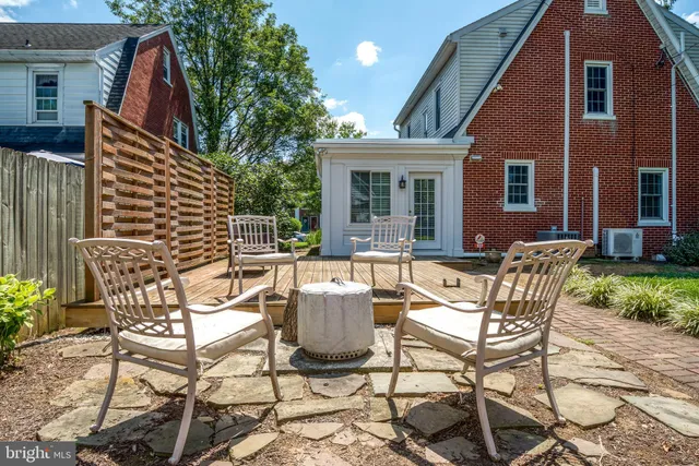 a view of a patio with table and chairs and wooden fence