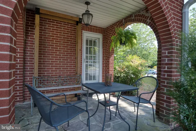 a patio with table and chairs and potted plants