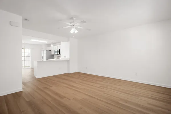 a view of empty room with wooden floor and window