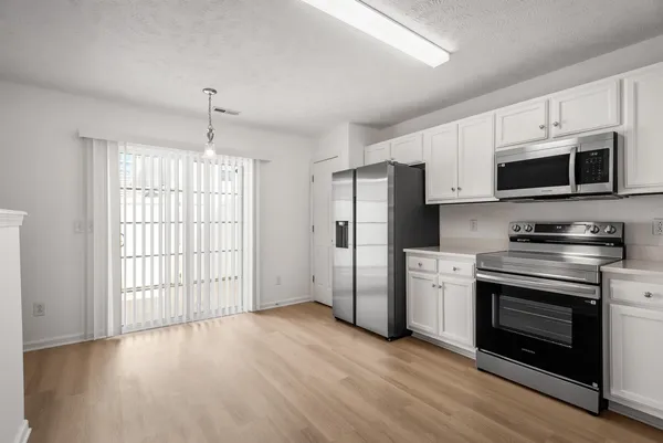 a view of a kitchen with a sink stove and refrigerator