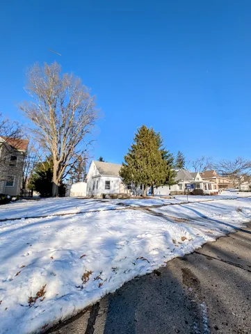 a view of a yard and car parked on the road