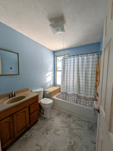 a bathroom with a granite countertop sink toilet and shower