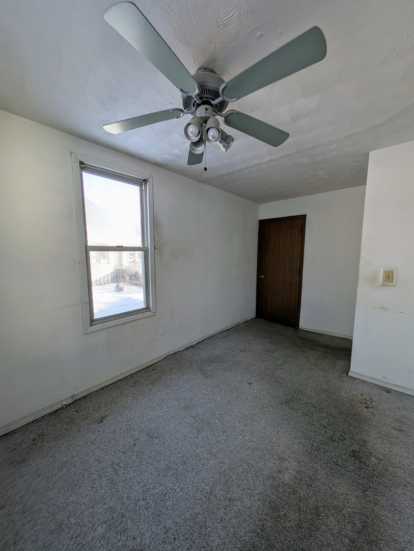 543 East 3rd Street El Paso, IL 61738 - Photo 15 of 21 an empty room with a ceiling fan and window