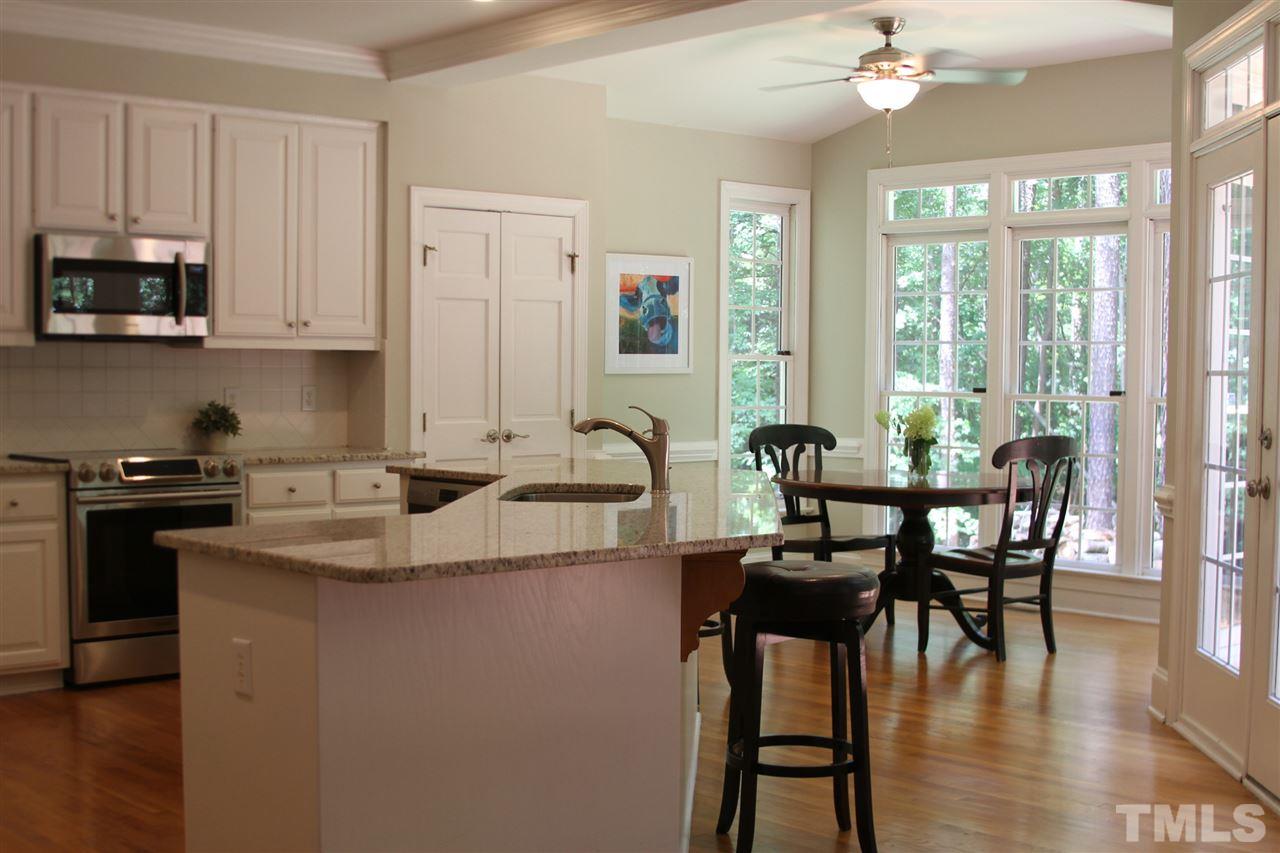 4205 White Chapel Way Raleigh, NC 27615 - Photo 2 of 8 a kitchen with stainless steel appliances granite countertop a table chairs stove and sink
