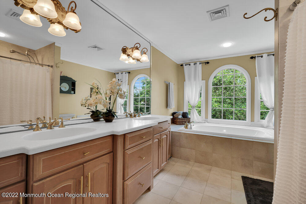 1722 Burrsville Road Brick, NJ 08724 - Photo 55 of 71 a spacious bathroom with a granite countertop sink a large mirror and a bathtub next to a window