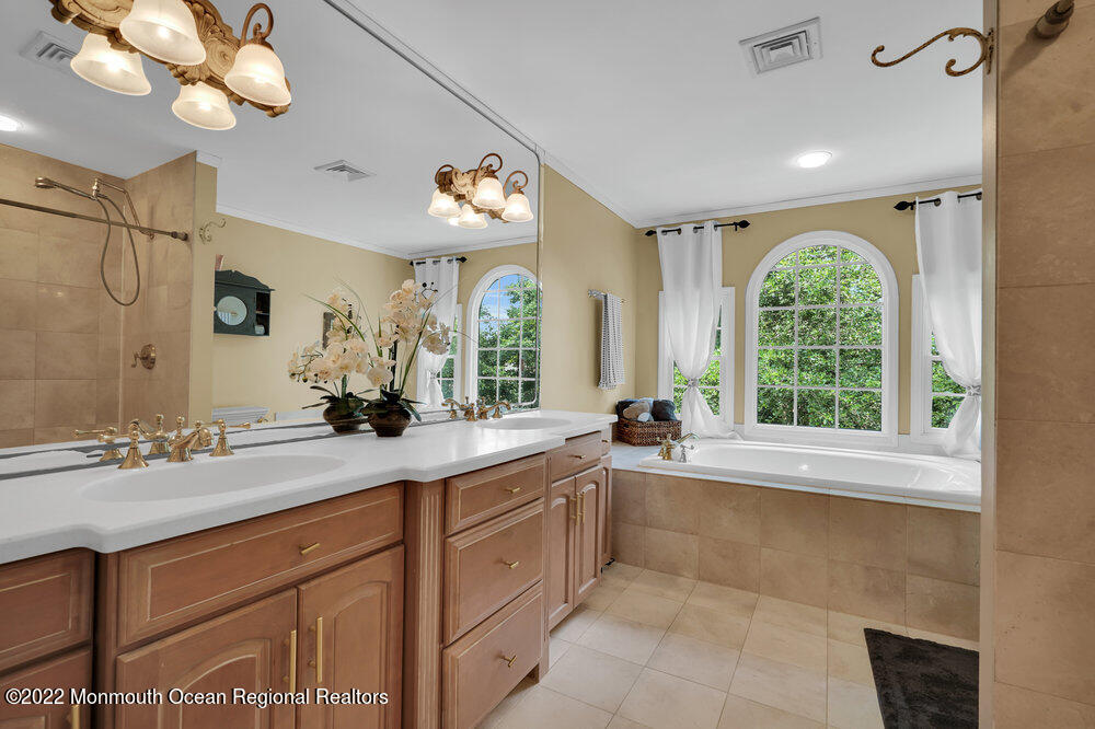 1722 Burrsville Road Brick, NJ 08724 - Photo 56 of 71 a spacious bathroom with a granite countertop sink a large mirror and a bathtub next to a window