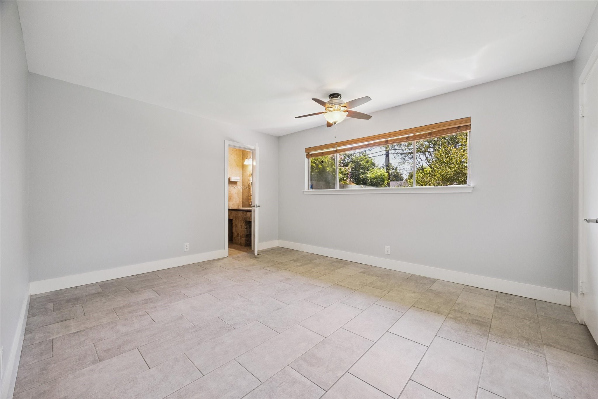 9407 Meadowbriar Lane Houston, TX 77063 - Photo 23 of 31 an empty room with windows and ceiling fan