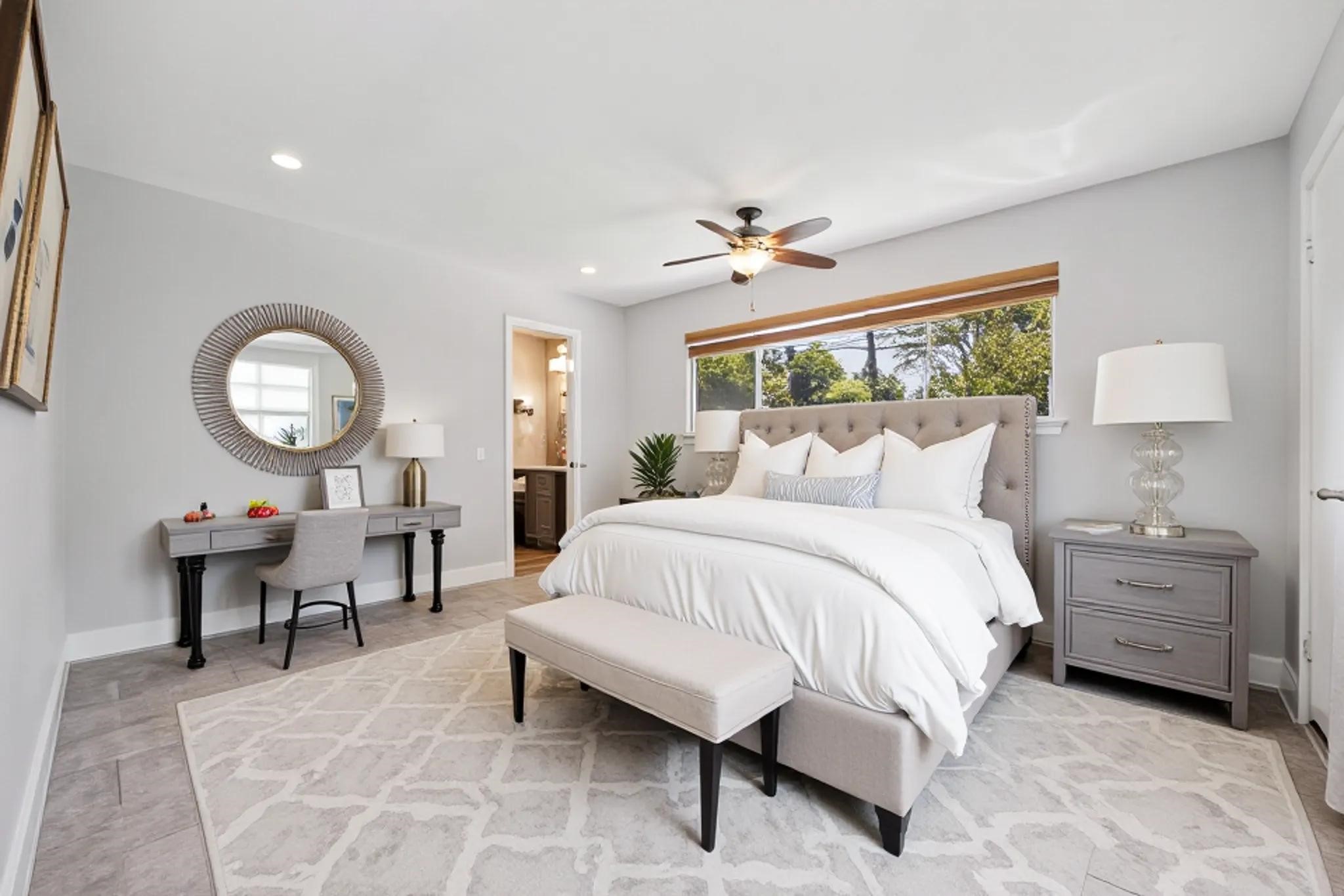 9407 Meadowbriar Lane Houston, TX 77063 - Photo 5 of 31 a spacious bedroom with a bed a chandelier windows and chair