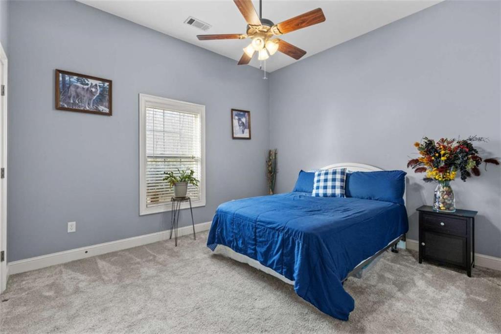 8399 East Carroll Road Whitesburg, GA 30185 - Photo 18 of 52 a bedroom with a bed and a chandelier