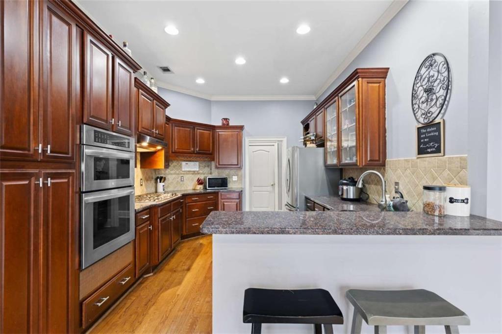 8399 East Carroll Road Whitesburg, GA 30185 - Photo 9 of 52 a kitchen with stainless steel appliances granite countertop a stove a sink and a microwave
