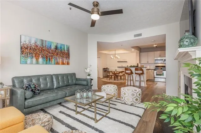 a living room with furniture kitchen view and a chandelier