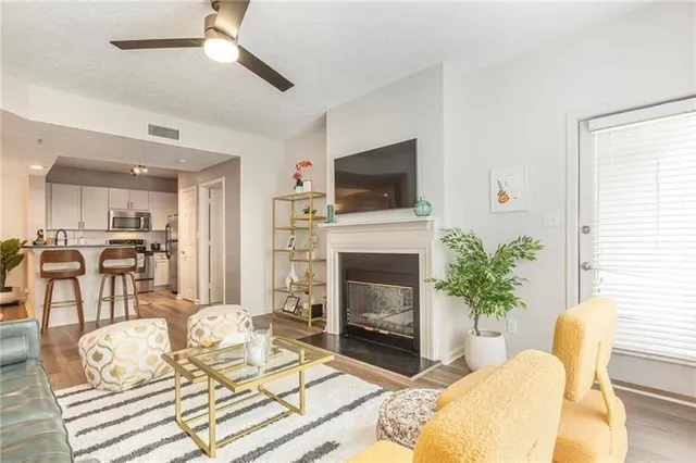 a living room with furniture a flat screen tv and a fireplace