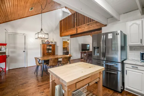 a kitchen with a table chairs refrigerator and cabinets