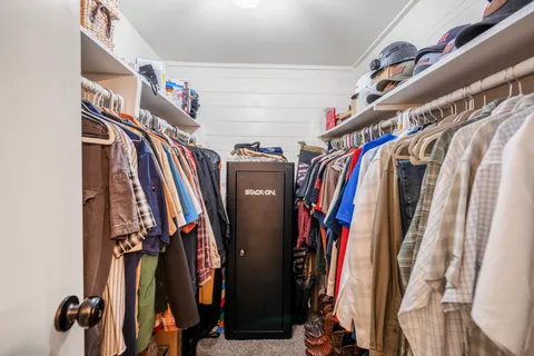 a view of walk in closet with clothes and shoes